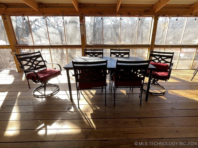 sunroom / solarium featuring beamed ceiling