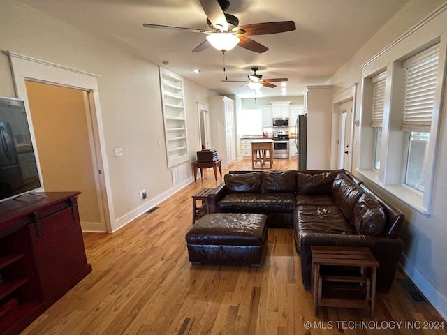 living room featuring hardwood / wood-style floors and ceiling fan