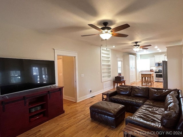 living room featuring light wood-type flooring and ceiling fan