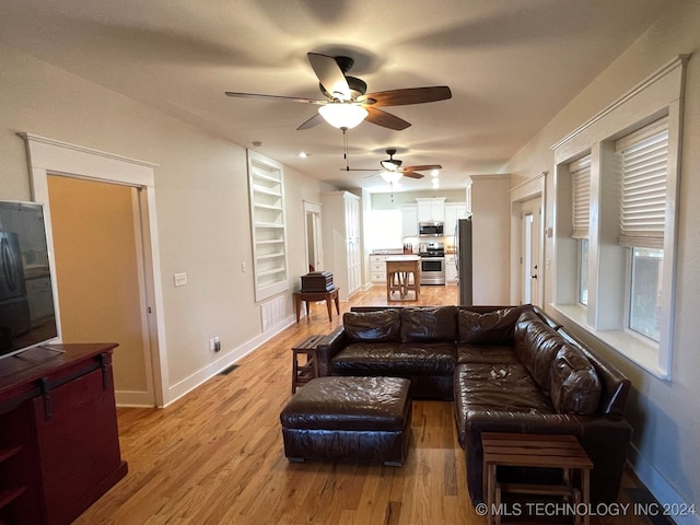 living room with ceiling fan and hardwood / wood-style flooring