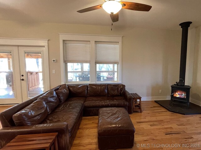 living room featuring a wood stove, plenty of natural light, hardwood / wood-style floors, and ceiling fan