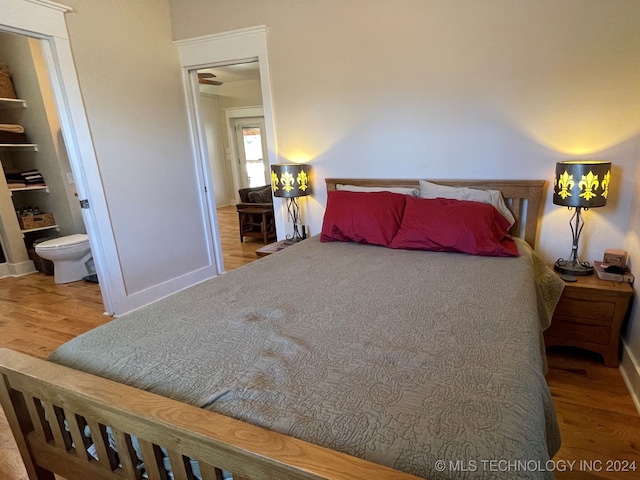 bedroom featuring ensuite bath and hardwood / wood-style flooring