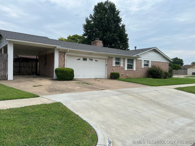 single story home with a front lawn, a carport, and a garage