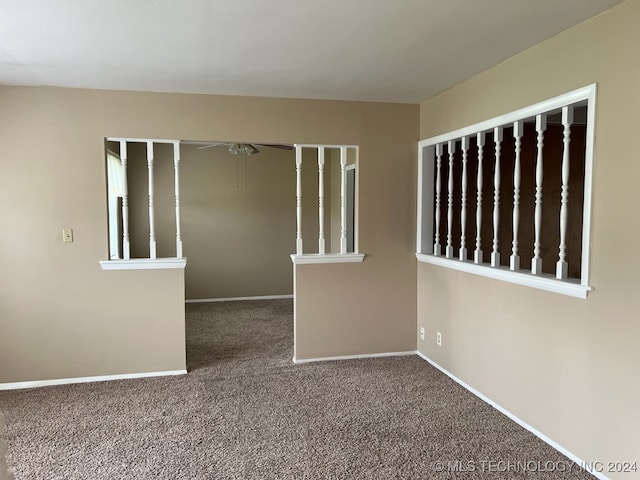 unfurnished room with ceiling fan and carpet