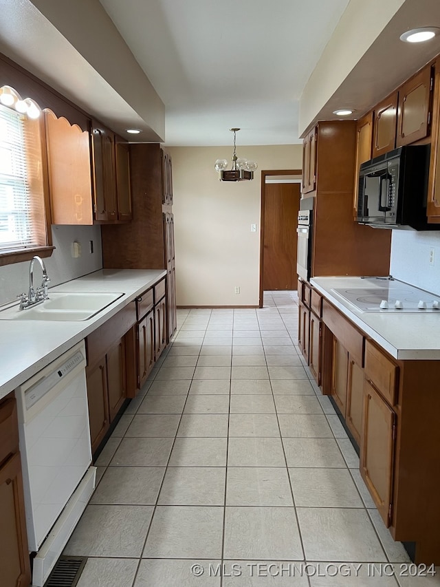 kitchen featuring sink, hanging light fixtures, white appliances, and light tile patterned floors