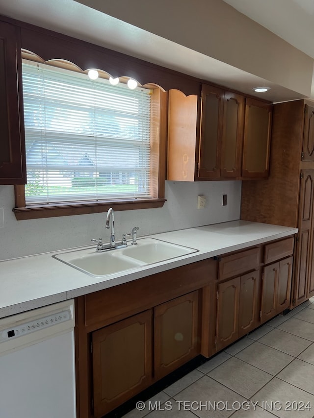 kitchen featuring sink, white dishwasher, and light tile patterned floors