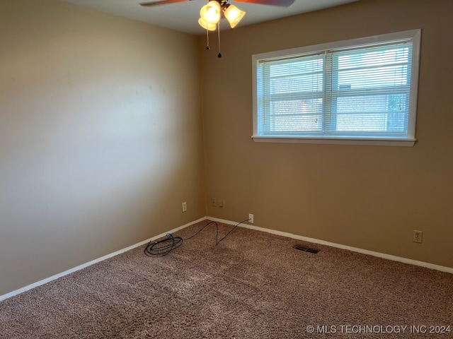 carpeted spare room featuring ceiling fan