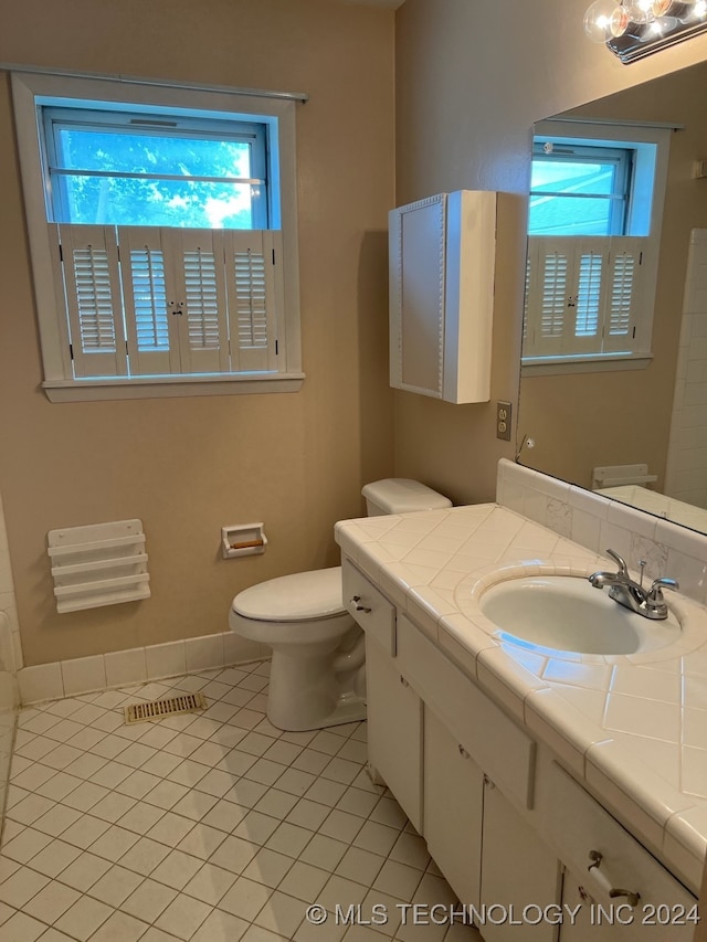 bathroom with tile patterned flooring, toilet, and vanity