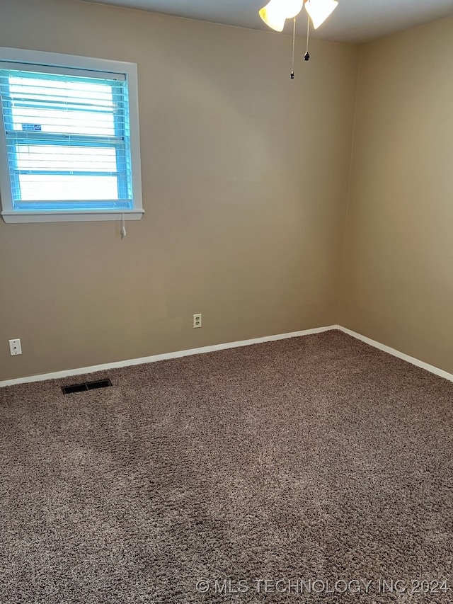 carpeted spare room featuring ceiling fan