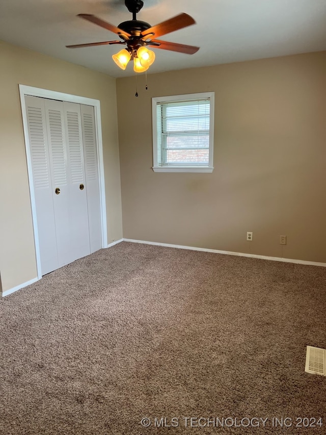 unfurnished bedroom with carpet floors, ceiling fan, and a closet