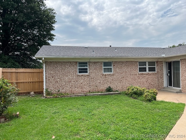 rear view of house featuring a yard