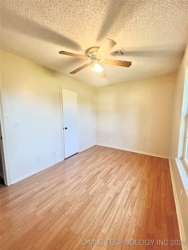 empty room featuring a textured ceiling, ceiling fan, and light hardwood / wood-style floors