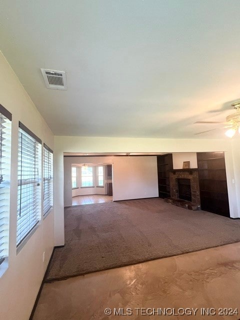 unfurnished living room with carpet and ceiling fan