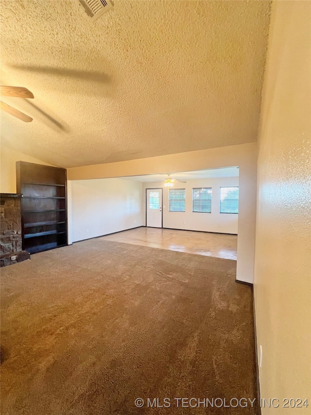 bonus room featuring a textured ceiling, carpet, ceiling fan, and a fireplace