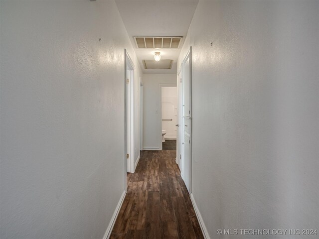 corridor with dark hardwood / wood-style flooring