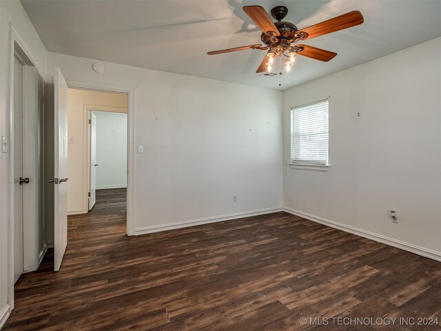 empty room featuring ceiling fan and dark hardwood / wood-style flooring