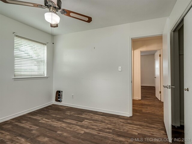 spare room featuring ceiling fan and dark wood-type flooring