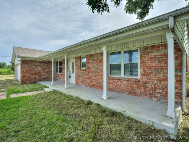 rear view of house featuring a patio and a lawn