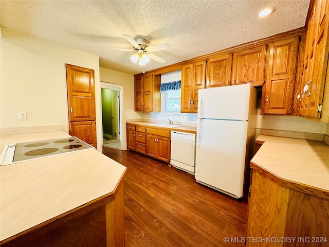 kitchen featuring dark hardwood / wood-style floors, sink, a textured ceiling, white appliances, and ceiling fan