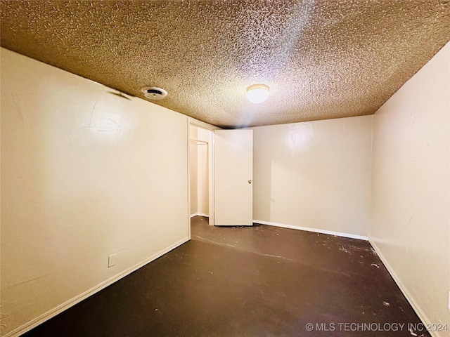 unfurnished room with a textured ceiling