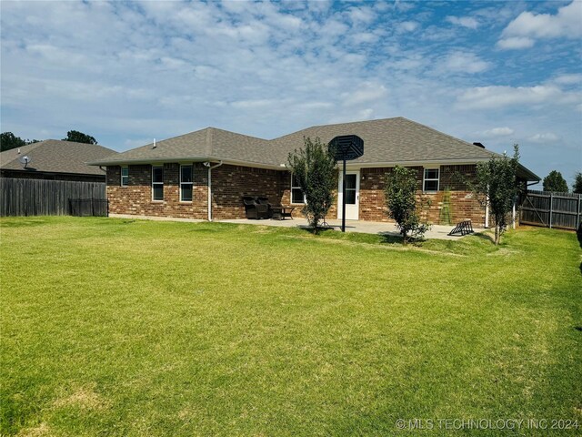 rear view of property featuring a patio and a yard