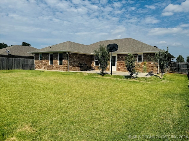 rear view of property with brick siding, a fenced backyard, a yard, and a patio