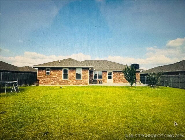 back of house featuring a patio and a yard