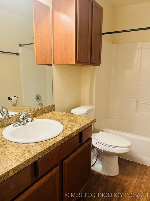 full bathroom with toilet, hardwood / wood-style flooring, bathtub / shower combination, and vanity