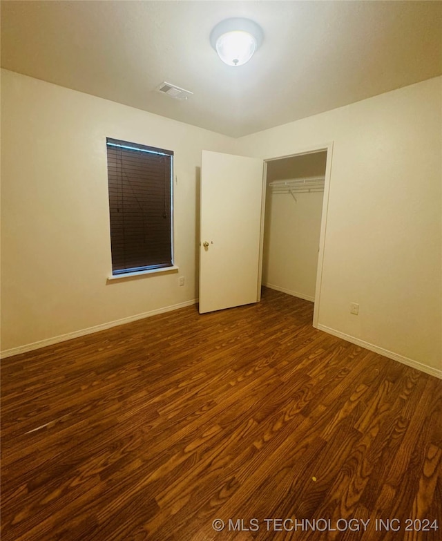 unfurnished bedroom with baseboards, visible vents, and wood finished floors