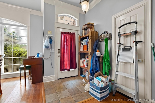 foyer with crown molding and baseboards