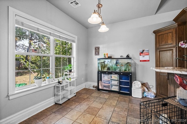 interior space with hanging light fixtures, baseboards, and visible vents