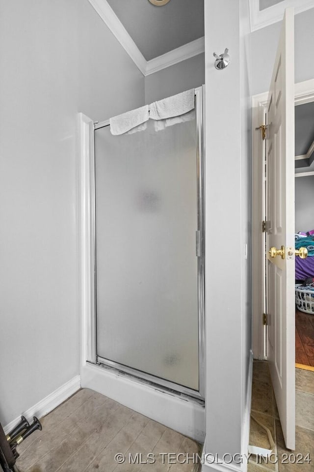 full bath with a stall shower, crown molding, and wood finished floors