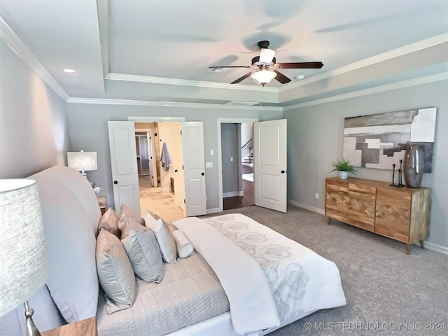 bedroom with carpet floors, baseboards, a tray ceiling, and crown molding