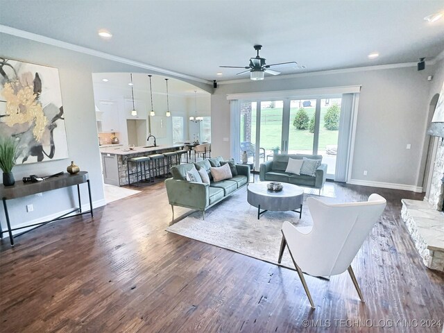 living room with ceiling fan, crown molding, and wood-type flooring