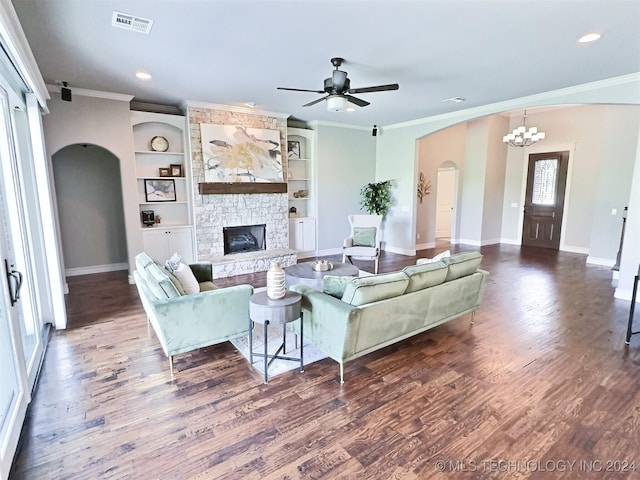 living room featuring dark wood-style floors, arched walkways, a fireplace, visible vents, and baseboards