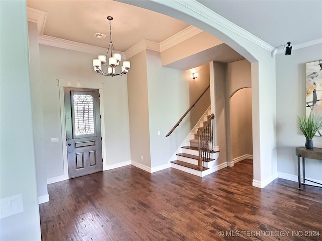 entrance foyer with ornamental molding, arched walkways, dark wood finished floors, and baseboards