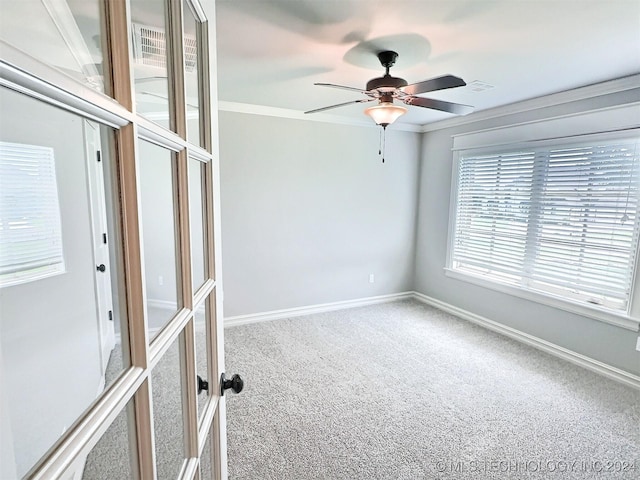 unfurnished room with carpet flooring, a ceiling fan, visible vents, baseboards, and ornamental molding