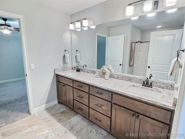 bathroom with a sink, baseboards, and double vanity