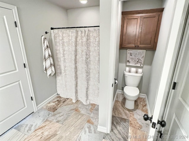 full bathroom with curtained shower, toilet, and baseboards