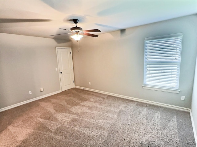 spare room with carpet floors, ceiling fan, and baseboards