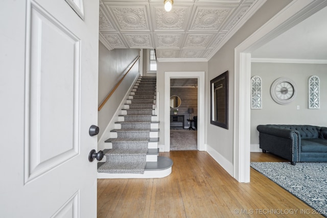 staircase featuring hardwood / wood-style flooring and ornamental molding