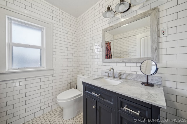 bathroom with tile walls, vanity, curtained shower, tile patterned floors, and toilet