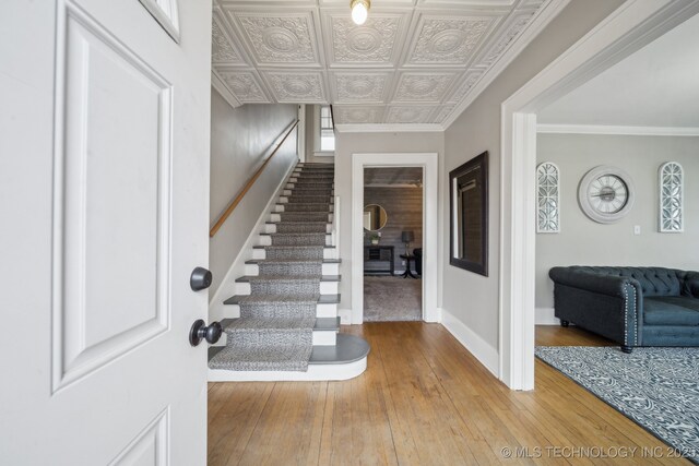 1715 Grandview Ave, Pawhuska, OK 74056 - entrance foyer with hardwood / wood-style flooring, stairs, ornamental molding, and an ornate ceiling