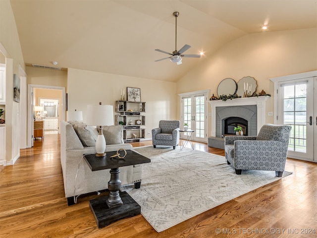 living room featuring light wood-type flooring, ceiling fan, and a fireplace