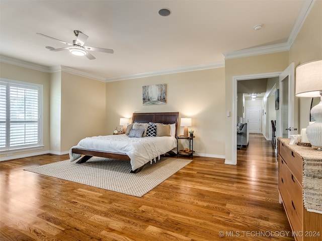 bedroom featuring ceiling fan, dark hardwood / wood-style floors, and crown molding