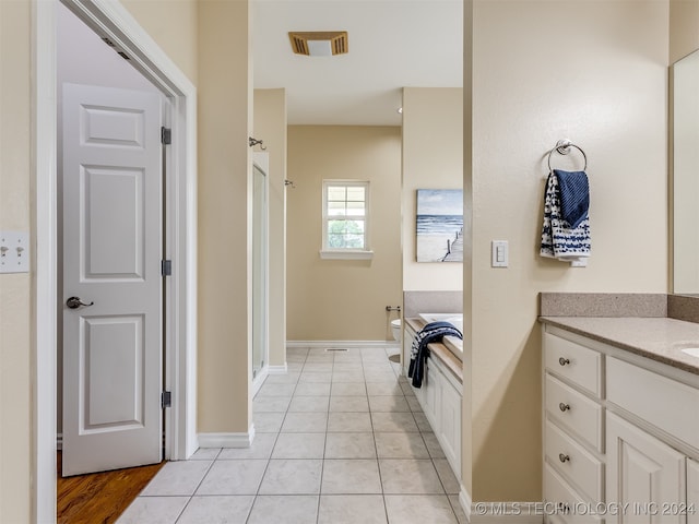 bathroom with vanity, an enclosed shower, and tile patterned floors