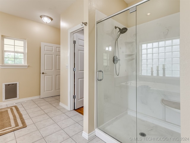 bathroom with heating unit, tile patterned floors, and a shower with door