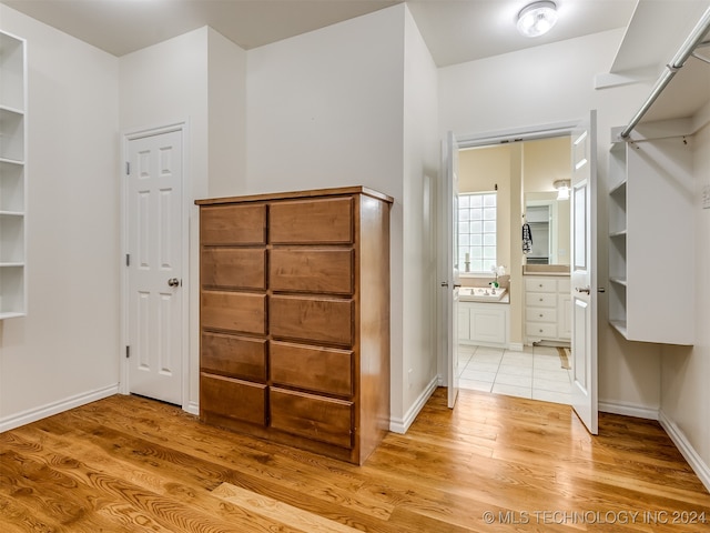 walk in closet with light hardwood / wood-style flooring