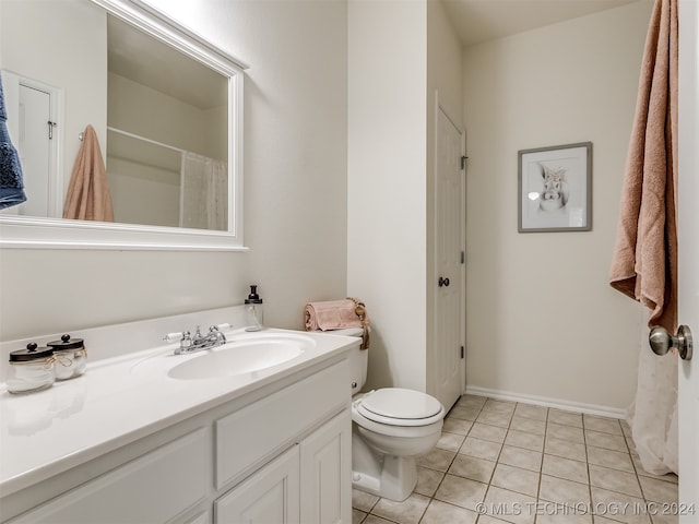 bathroom with tile patterned floors, a shower with shower curtain, toilet, and vanity