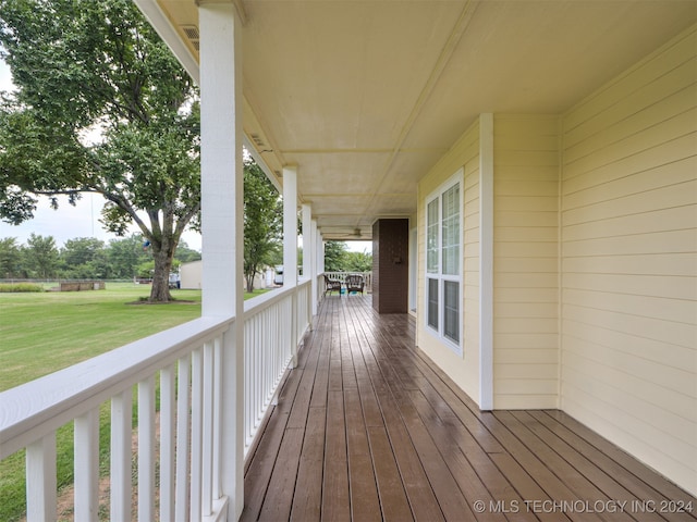 wooden deck with a lawn and a porch